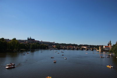 Boats in river with city in background