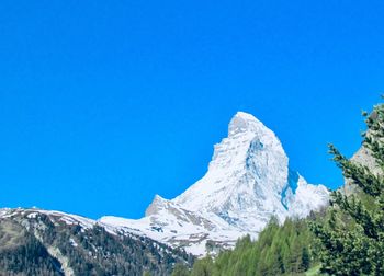 Scenic view of snowcapped mountains against clear blue sky