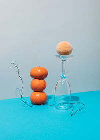 Fresh tangerine tower and frozen tangerine with glass against blue background. creative concept
