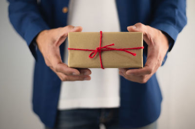 Midsection of man holding paper in box