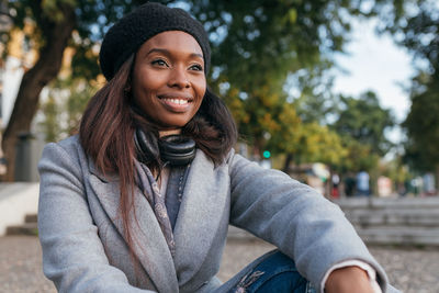 Portrait of smiling young woman sitting outdoors
