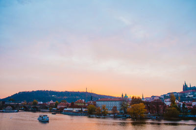 View of buildings at waterfront during sunset