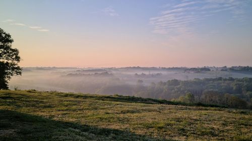 Scenic view of landscape against sky during foggy weather