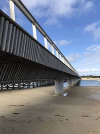 Built structure on beach by sea against sky