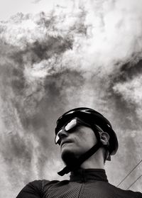 Low angle view of mature man wearing bicycle helmet against sky