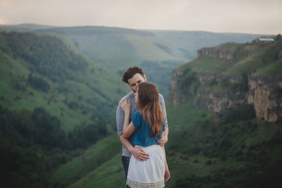 Rear view of man standing on cliff