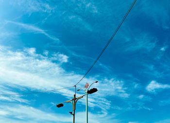 Low angle view of street light against blue sky