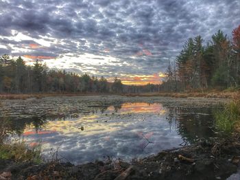 Scenic view of calm lake against cloudy sky