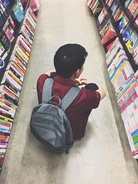 High angle view of girl sitting on book at home