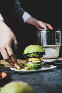 Midsection of man preparing food in plate