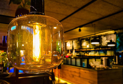 Close-up of illuminated light bulb in restaurant