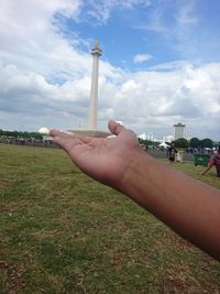 Midsection of person holding umbrella against sky