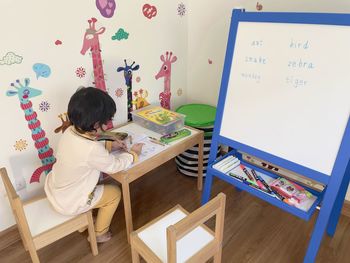 Rear view of a boy sitting on seat at home
