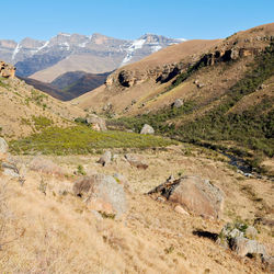 Scenic view of land and mountains against clear sky