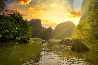 Scenic view of river against sky during sunset