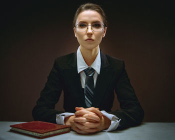 Portrait of young businesswoman sitting on table