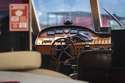 View of the varnished wooden steering wheel of a marine yacht, control devices, gauges, button