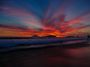 Scenic view of sea against dramatic sky during sunset