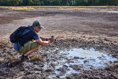 Hiker visits the caldera, a small circular crater with a marsh of sulphurous waters from the volcano