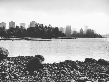 Scenic view of sea by buildings against sky