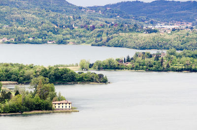 Scenic view of river by trees against sky