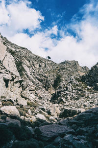 Low angle view of rocks on mountain against sky