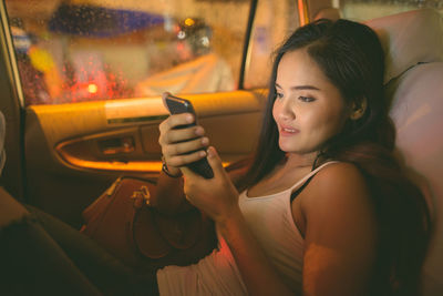 Portrait of young woman holding a car