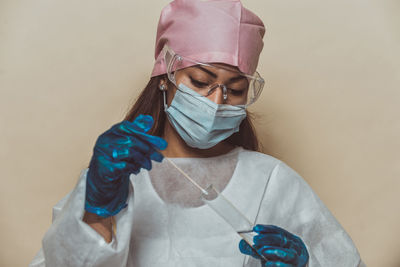 Doctor wearing mask against blue background