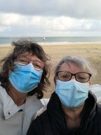 Portrait of senior women wearing mask standing on beach