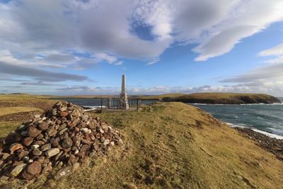 Stack of rocks on shore against sky