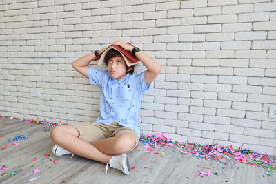 Cute girl sitting against wall