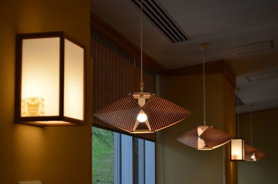 Illuminated pendant lights hanging from ceiling at home