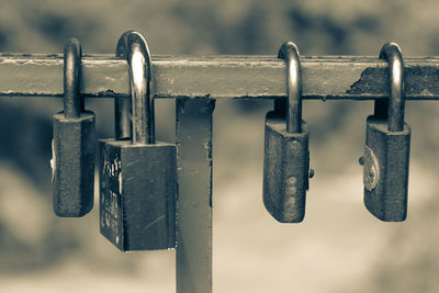 Close-up of padlocks hanging on metallic railing