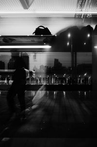 Blurred motion of people walking in illuminated city at night