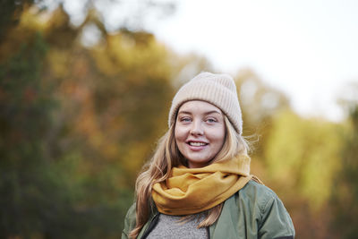 Portrait of young woman wearing hat standing outdoors