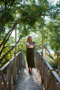 Full length of woman standing on footbridge