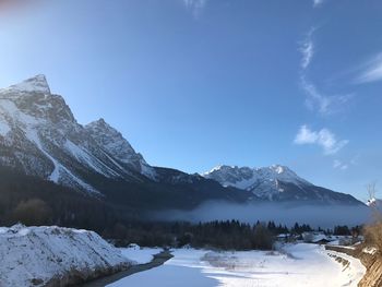 Scenic view of snowcapped mountains against blue sky