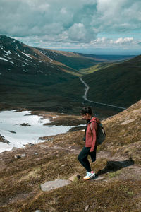 Woman looking at view of mountains against sky