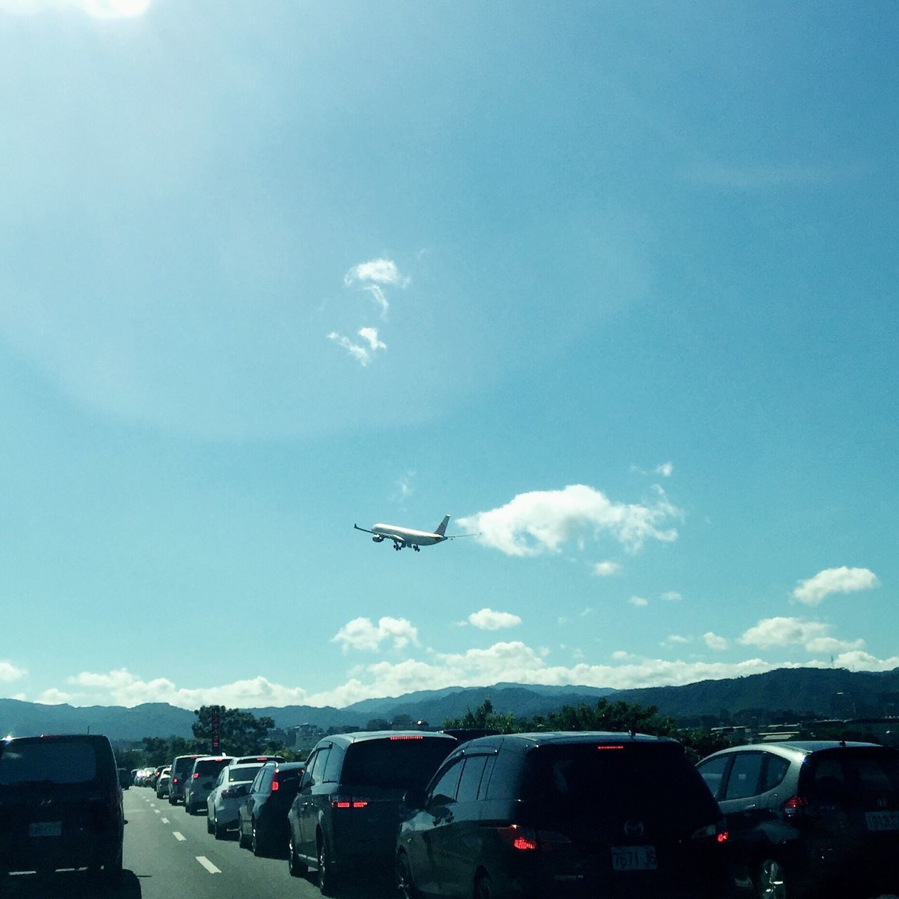 AIRPLANE FLYING OVER ROAD