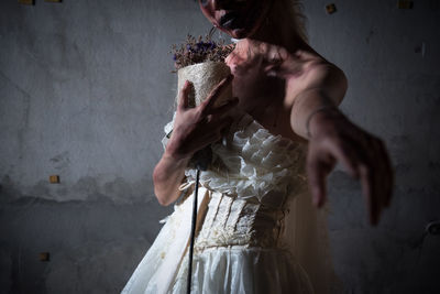 Young woman with spooky make-up against wall