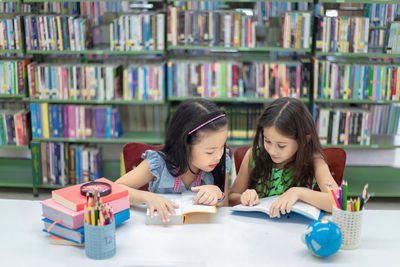 Two women sitting on table