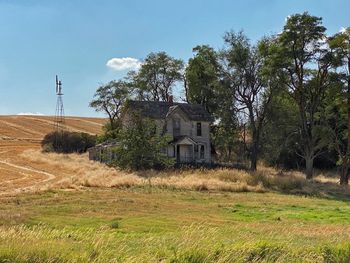 Abandoned house on field against sky