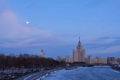 Buildings in city against cloudy sky