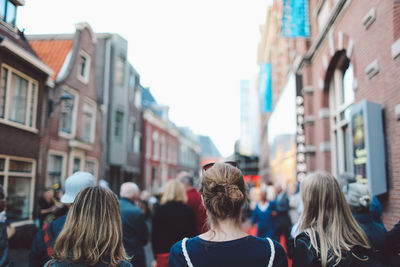 Rear view of people walking on city street