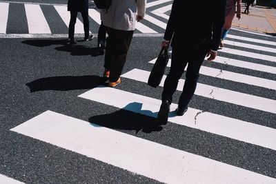 Low section of people walking on zebra crossing