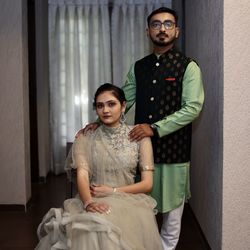 Portrait of young couple standing against wall