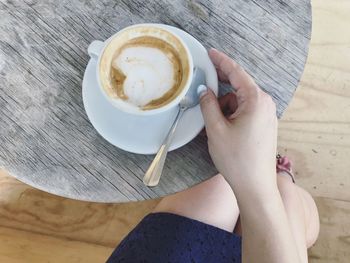 Low section of woman having coffee