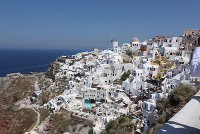 High angle view of townscape by sea against clear sky