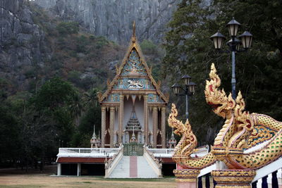 Dragon sculptures by temple against mountain