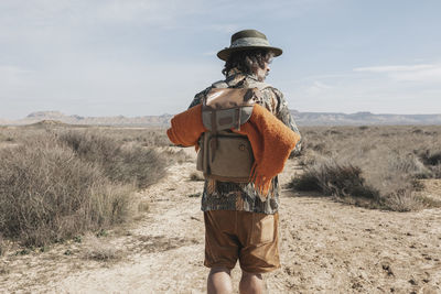 Rear view of a man with a backpack in the bardenas desert. navarre